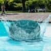 Poolboll som hoppar i poolen med vattenstänk.