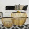 Elegant guld-runt soffbord i modern inredning.