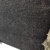 Närbild av texturerad sittkudde i svart och beige färger.