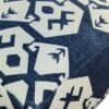 Detaljerad bild av kudde med blå och vit geometrisk mönster.