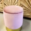 Ljus rosa sammetspall med guldfot, perfekt som sittplats eller dekorativt element.