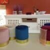 Färgglada velvet poufs med guldbas i vardagsrummet.