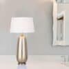 Elegant bordslampa i metall Silver/Guld på vit bänkskiva.
