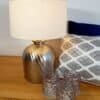 Elegant bordslampa med silverfärgad metallbas och vit lampskärm.