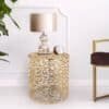Elegant rund sidobord i guld eller silver med öppet design.