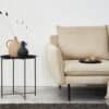 Soffbord i svart metall bredvid beige soffa i vardagsrummet.