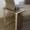 Kaffbord med laptop och glas vid soffan i vardagsrummet.