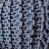 Detaljerad bild av stickad pallpuff i jeansblå färg.