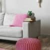 Rosa knytpuff som passar som sittplats eller fotpall i vardagsrummet.