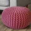 Rosa stickad sittpuff för golv eller sittplatser.