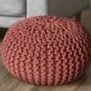 Rosa stickad sittpuff för golv eller sittplatser.