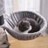 Ljusgrått kattträd med katt som vilar i en mysig kattlägenhet.