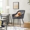 Mörkgrå fåtölj med hund som ligger på den i ett modernt vardagsrum.