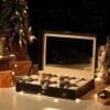 Elegant svart watchbox med 12 fack och glaslock för klockförvaring.