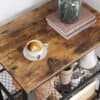 Kaffekopp på träbord med serveringsvagn och böcker.