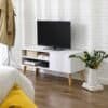 Vit TV-bänk i skandinavisk stil med TV och växt i vardagsrum.