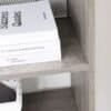 Modern greige bokhylla med böcker och dekorativa föremål.