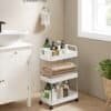 Vit tre-lagers förvaringsvagn med hjul och handtag för badrum eller kök.