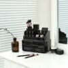 Svart makeup- och sminkförvaringslåda med borstar och kosmetika.