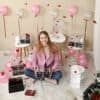 Kvinna med makeup- och sminkförvaringsboxar i festlig miljö.