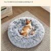 Ljusgrå fluffig hundsäng med liten hund som vilar i den.