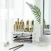 Transparent makeup- och kosmetikorganizer med 3 lådor och skönhetsprodukter.