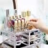Transparent makeup- och sminkorganisator med nagellack och kosmetika.