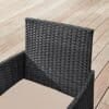Svart polyrattan lounge stol för utomhusbruk på trädäck.
