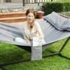 Avslappnad kvinna i hammock på trädgården, utomhus.