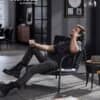 Modern lounge chair with black faux leather and metal frame in stylish room.