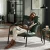 Modern lounge chair with black metal frame and green cushion in living room.