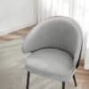 Ljusgrå stoppad matstol med armstöd och metallben i modern design.