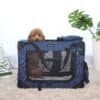 Mörkblå hundtransportväska med hund inuti, lätt att bära och transportera husdjur.