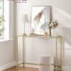 Elegant guldkonsolbord med glas och blomsterarrangemang.