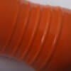 Närbild av orange vattenflaska i stål med ribbade detaljer.