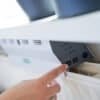 Bilden visar en hand som justerar en kontrollpanel på en SmartAir Boost radiatorfläkt.
