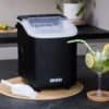Svart bärbar isbitmaskin med skopa för kyliga drycker.