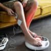 Person använder fotstimulator för muskelavslappning och rehabilitering.