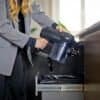 Person använder handdammsugare för att rengöra kontorsavfall.