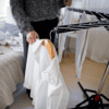 Person som hänger tvätt på en inomhus tvättlina.