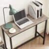 Moderne skrivbord med laptop, bordslampa och dokumentfack i hemmet.