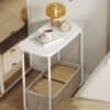Modern nattduksbord med glas- och marmorelement.