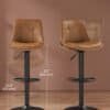 Två köksstolar med justerbar höjd och svängfunktion i karamellbrunt läder.