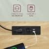 Eluttag med USB-portar och strömkabel på skrivbord.