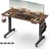 Höjdjusterbart skrivbord med två skärmar, tillbehör och förvaring.