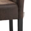 Detalj av barstol med svart träben och brunt läderlook tyg.