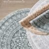 Rundmatta i boho-stil med intricate mönster i grå, beige och vit färg.
